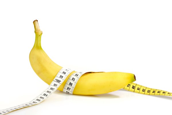 банан с сантиметром на белом фоне