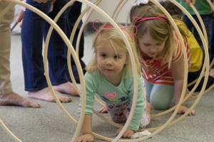 Children climb through a hoop