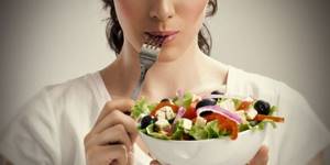 Girl holding a plate with salad