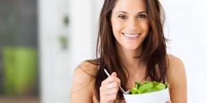 Girl holding a plate with salad