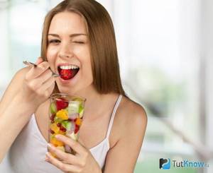 Девушка кушает фруктовый салат