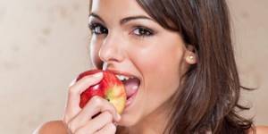Девушка кушает яблоко