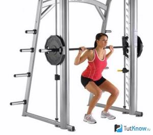 Girl squats on a Smith machine