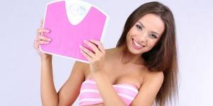 Girl with bathroom scales in her hands