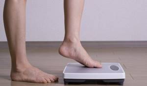 The girl gets on the scales