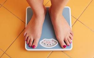 girl weighs herself on a bathroom scale