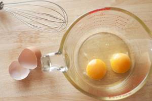 Two yolks with whites in a measuring bowl