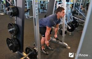 An athlete performing partial repetitions on a Smith machine