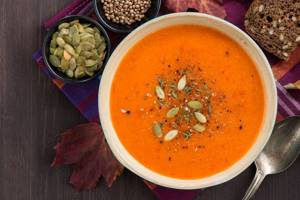 Garnish a plate of soup with roasted pumpkin seeds and dried basil