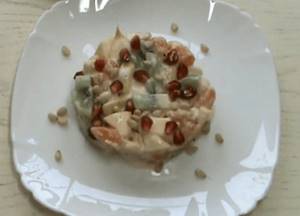 Decorate the salad with pine nuts and pomegranate seeds