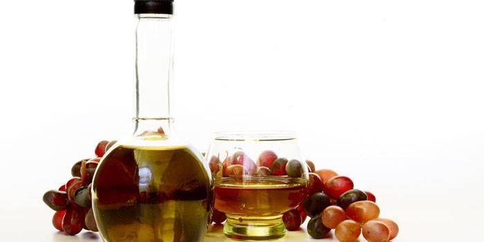 Wine vinegar in a vessel and grapes