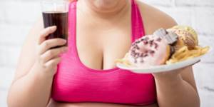 Woman-holding-Cola-and-donuts-reduce-stomach-size-Lara-Serebryanskaya
