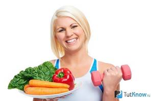 Woman with a plate of vegetables and dumbbells