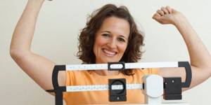 Woman weighing herself on scales
